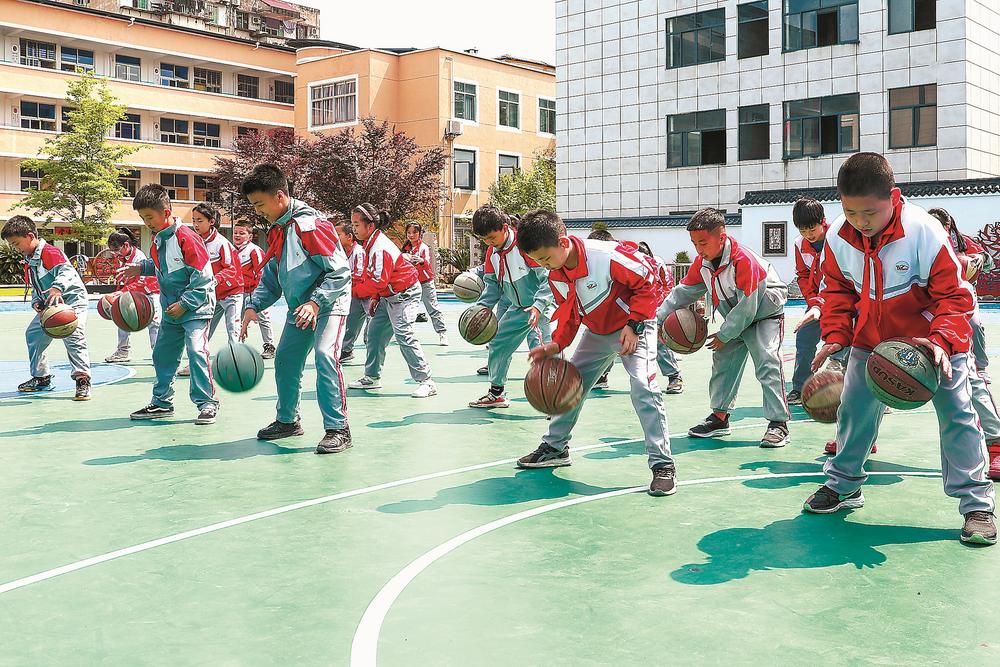 武夷山市余庆小学学生在体育课上进行篮球训练