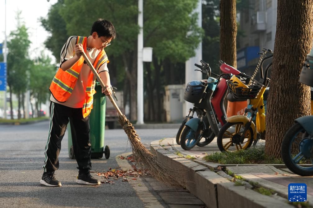  Xinhua All Media+"I Help Mom Sweep the Street" - Warm the Street with Broom in Small Hands