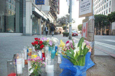 纪念人群将蜡烛、花束摆放在相距塞西尔酒店十余步之遥的一颗小树下，表达对逝者的哀思。（美国《世界日报》／高梓原摄影）