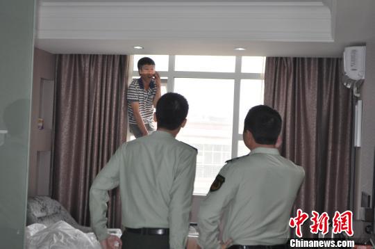 图为消防官兵对欲跳楼的男子进行劝说。　何杨　摄src=