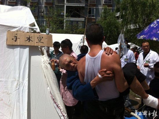儿子抱着父亲在芦山临时帐篷医院等待手术(图)