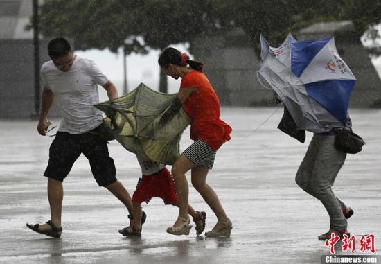 8月14日,强台风"尤特"袭击香港.图为香港街头市民顶风冒雨,艰难前行.