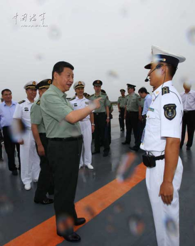 习近平一直十分关心我国第一艘航空母舰建设和部队训练。28日上午，他一下飞机就冒着风雨来到海军某舰载机综合试验训练基地，观看舰载机滑跃起飞、阻拦着陆训练，实地察看有关设备。当天下午，习近平又风雨兼程赶往大连，登上停泊在大连港的辽宁舰。摄影：解放军报记者周朝荣