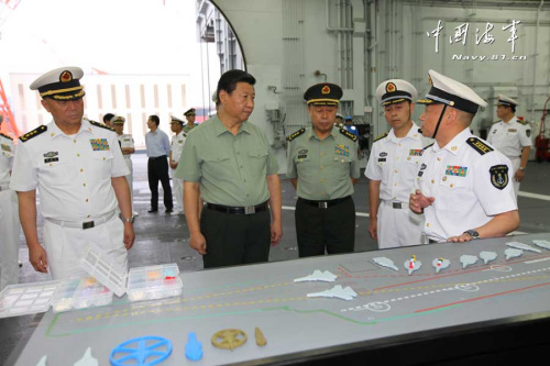 习近平一直十分关心我国第一艘航空母舰建设和部队训练。28日上午，他一下飞机就冒着风雨来到海军某舰载机综合试验训练基地，观看舰载机滑跃起飞、阻拦着陆训练，实地察看有关设备。当天下午，习近平又风雨兼程赶往大连，登上停泊在大连港的辽宁舰。摄影：解放军报记者周朝荣