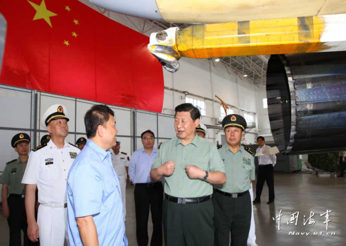 习近平一直十分关心我国第一艘航空母舰建设和部队训练。28日上午，他一下飞机就冒着风雨来到海军某舰载机综合试验训练基地，观看舰载机滑跃起飞、阻拦着陆训练，实地察看有关设备。当天下午，习近平又风雨兼程赶往大连，登上停泊在大连港的辽宁舰。摄影：解放军报记者周朝荣