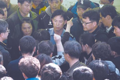 24日，韩国沉船遇难者家属将韩国海警队士兵以及政府官员拖出办公室，要求政府提高搜救的速度与效率。