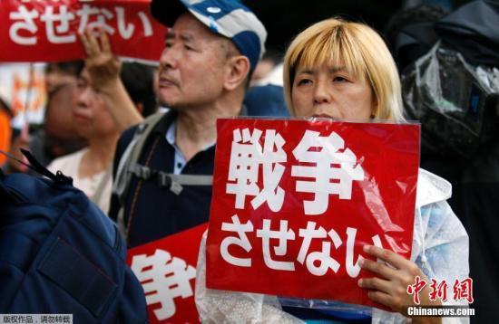 当地时间2015年7月16日，日本东京国会前，民众高举标语，抗议日本首相安倍晋三政府，以及议会表决通过新安保法案。