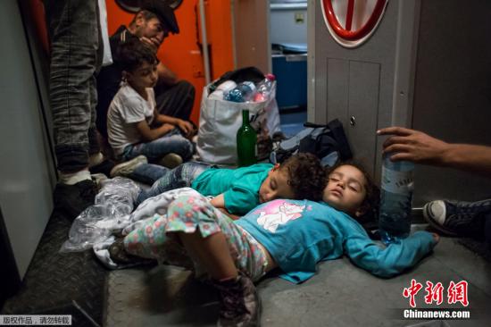 资料图：当地时间8月31日，匈牙利边境Hegyeshalom，在从布达佩斯前往慕尼黑的火车车厢的地板上，跟随着大人们一起流浪的小朋友睡的正香。