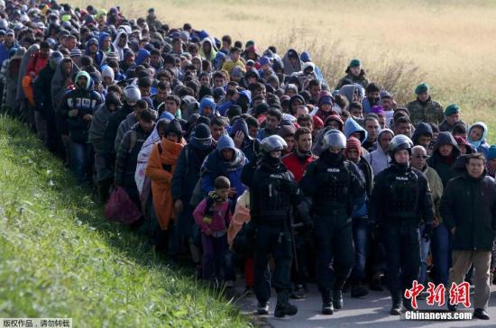 当地时间10月20日，在斯洛文尼亚与克罗地亚边境城市多波瓦，斯洛文尼亚全副武装的军警“护送”从克罗地亚入境的难民。走在最前面的警察骑马开道，数千难民拍着长队一路步行前往难民所。自上周六以来，数千名寻求避难的人进入了斯洛文尼亚境内，迫使该国着手处理南部边境出现的难民激增的情况。斯洛文尼亚当局表示，至少有4000名难民于周二抵达该国境内，其中包括很多婴儿和年幼的孩子，再加上已经于周一抵达的大约8000名难民。