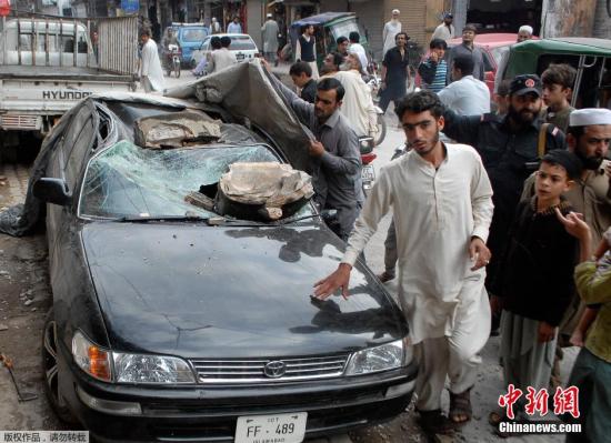 巴基斯坦白沙瓦街头，一辆汽车被地震中掉落的石块砸中。 据巴基斯坦媒体26日报道，当天发生的强烈地震已导致该国至少220人死亡、1200人受伤。