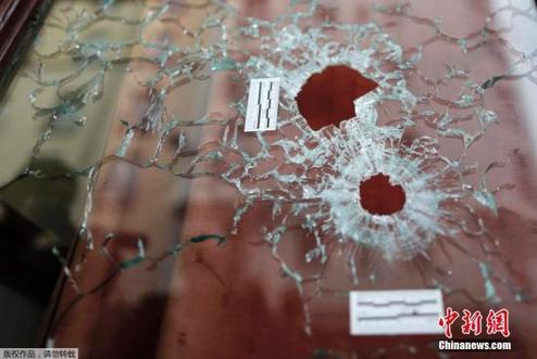 Le Carillon的酒吧的玻璃门上留有两颗弹孔，这是当时恐怖分子扫射路人时留下的。
