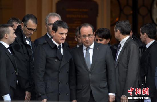 当地时间11月16日，法国举国哀悼巴黎恐怖袭击的遇难者。中午12时，全国民众默哀一分钟悼念死者。在各个遇袭地点，大批民众自发聚集鲜花燃烛表达纪念之情。这是这是《查理周刊》血案后不到一年时间内，法国第二次行国殇之礼。图为法国总统奥朗德和总理瓦尔斯在巴黎索邦大学参加默哀仪式。 龙剑武 摄
