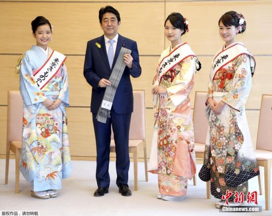 当地时间2015年12月8日，日本东京，首相安倍晋三在官邸接见“和服女王”，并获赠传统和服腰带。