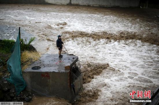 圣地亚哥民众看着河中奔腾的洪水。