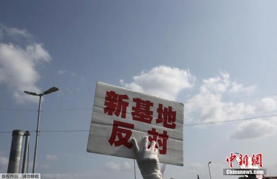 当地时间2015年3月23日，日本冲绳名护市，民众在美军施瓦布军营前示威，要求暂停边野古海底钻探作业，抗议美军普天间机场迁至名护市边野古。