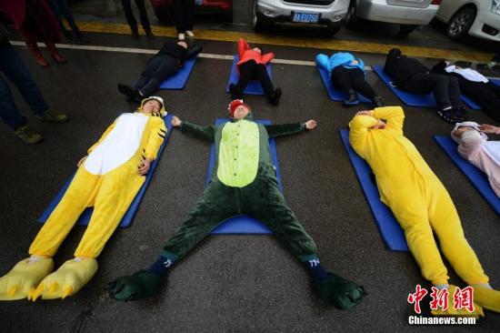 3月20日，世界睡眠日前夕，被誉为中国“睡眠先生”的唐堂带领众多市民来到长沙街头进行“睡大街”公益行为艺术展示。 杨华峰 摄