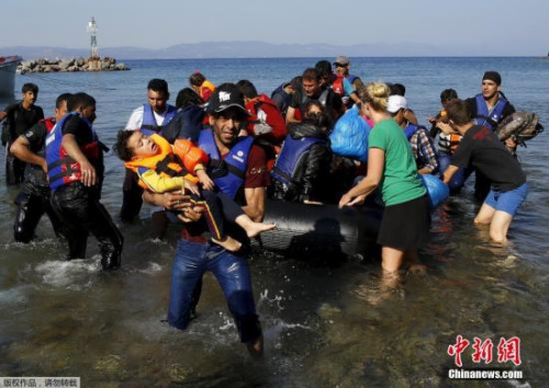 资料图：2015年9月20日，大批的难民从海上偷渡到土耳其，超载的船只在海上漂泊，救援人员抛下绳索解救了这一船难民。