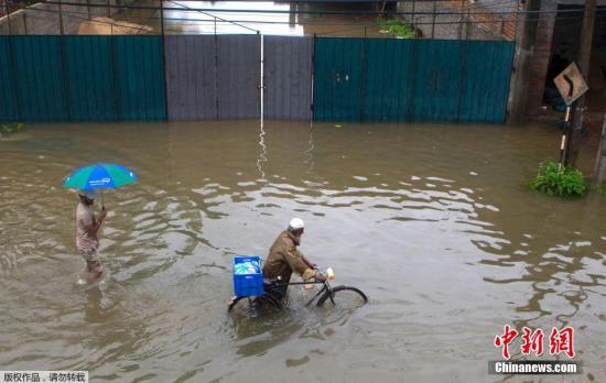 当地时间5月16日，斯里兰卡科伦坡遭遇暴雨引发洪水淹没街道，当地民众水中出行。