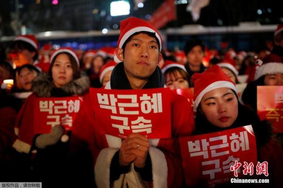 据悉，此次是韩国持续举行第9次“反朴槿惠”烛光游行。另一方面，在首尔德寿宫前，亲朴槿惠团体将举行“弹劾无效”的集会。图为青年穿圣诞服游行。