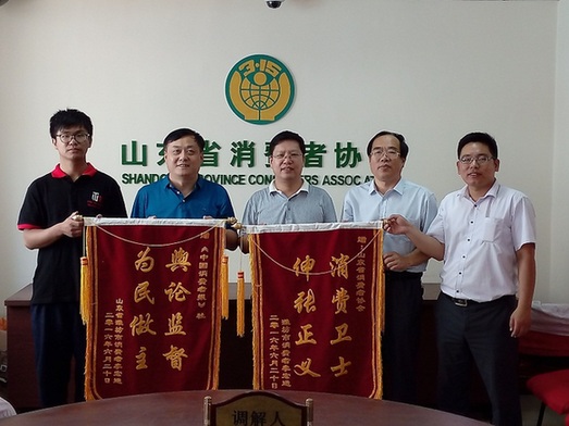 消费者为尹训银（左二）和山东省消费者协会送来锦旗。