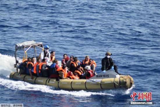资料图：当地时间2016年5月25日，利比亚近海海域，一艘满载难民的船只即将倾覆，船上的难民纷纷跳海逃生。