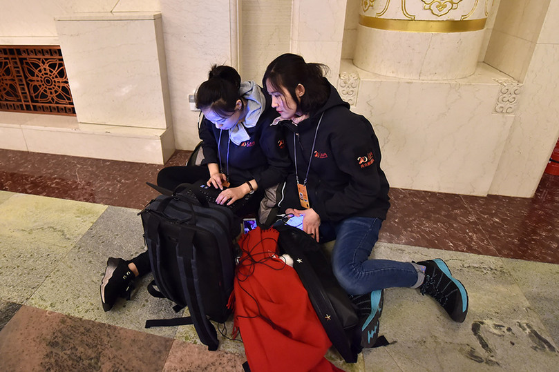 3月5日，人民网女记者席地而坐争分夺秒的在编发稿件。