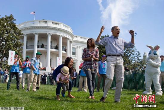 资料图：2014年4月21日，奥巴马夫妇在白宫举行复活节“滚蛋”比赛。上千个孩子在白宫的南草坪上追逐彩蛋，玩的兴高采烈。